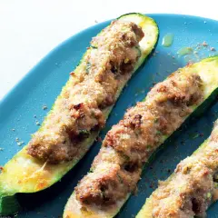 Zucchine ripiene velocissime, dorate e croccanti, servite su un piatto blu. Un piatto semplice e gustoso.