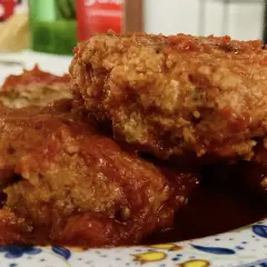 Polpette al sugo fumanti in una padella di ghisa, guarnite con prezzemolo fresco. Un classico confortante.