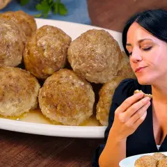 Una donna assapora deliziose polpette al forno, dorate e succulente, servite su un piatto bianco.