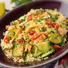 Un saporito cous cous con verdure, tonno e peperoncino, guarnito con scorza di limone e prezzemolo.
