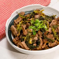 Straccetti di manzo saltati con verdure verdi e guarniti con cipollotto fresco. Un piatto saporito e invitante.