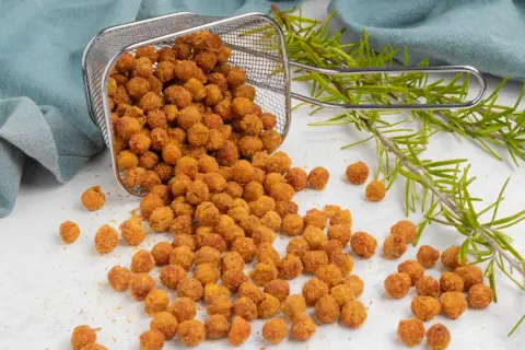 Ceci croccanti in friggitrice ad aria, appena usciti dal cestello, con rametti di rosmarino.