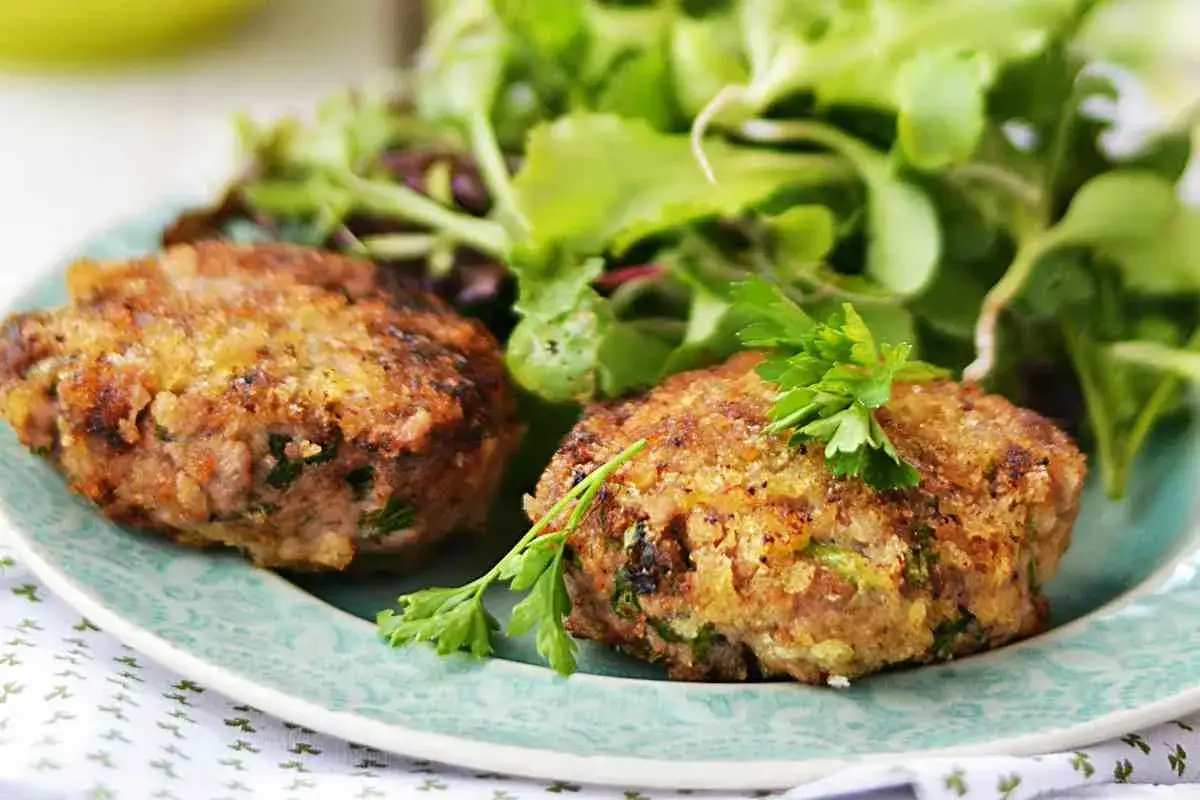 Deliziose polpette di zucchine e patate, dorate e croccanti, servite con un'insalata fresca.