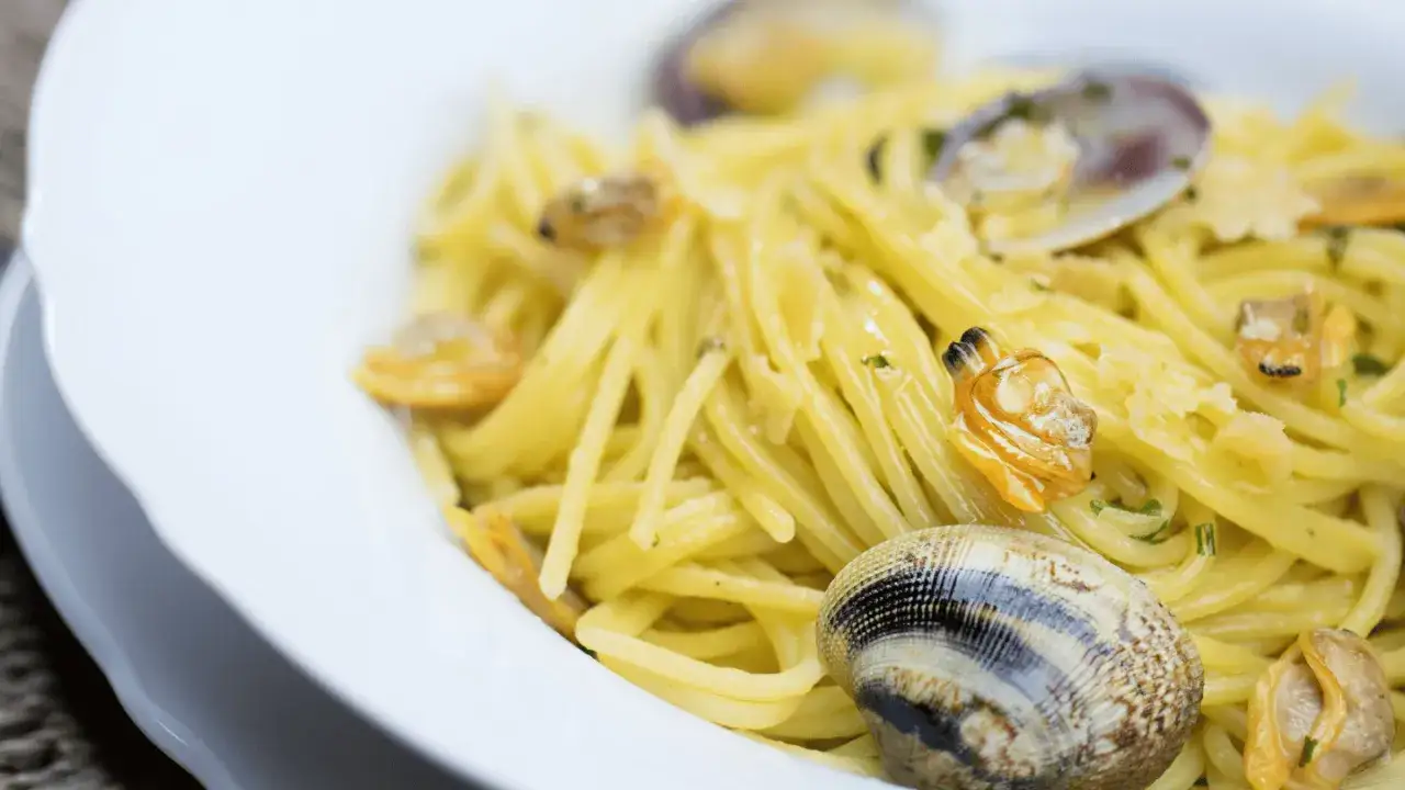 Un piatto invitante di linguine alle vongole, con pasta dorata e molluschi freschi, pronto per essere gustato.