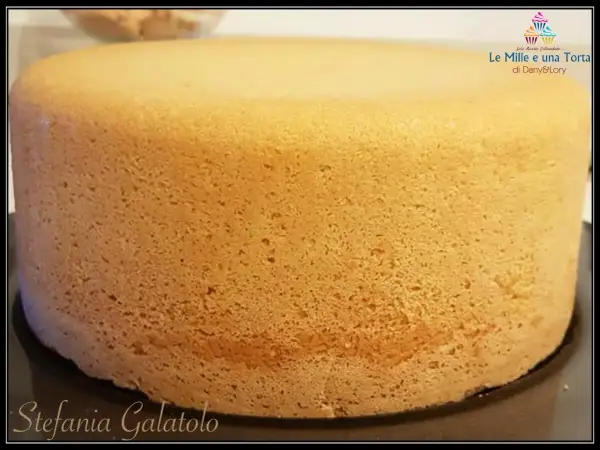 Un pan di spagna sofficissimo, dorato e invitante, pronto per essere farcito. La sua consistenza perfetta promette un dolce delizioso.